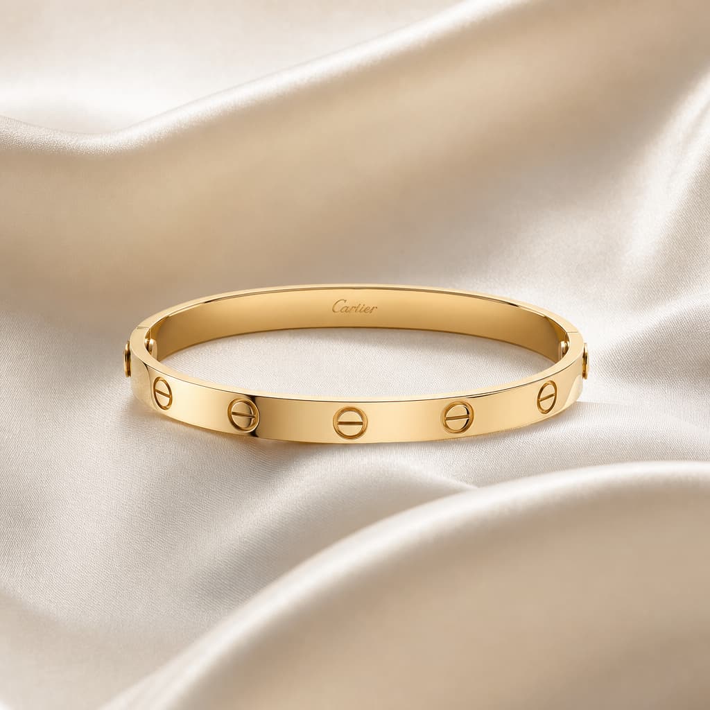 Bijoux Cartier — bracelet Love et bague Juste un Clou présentés sur un fond éditorial